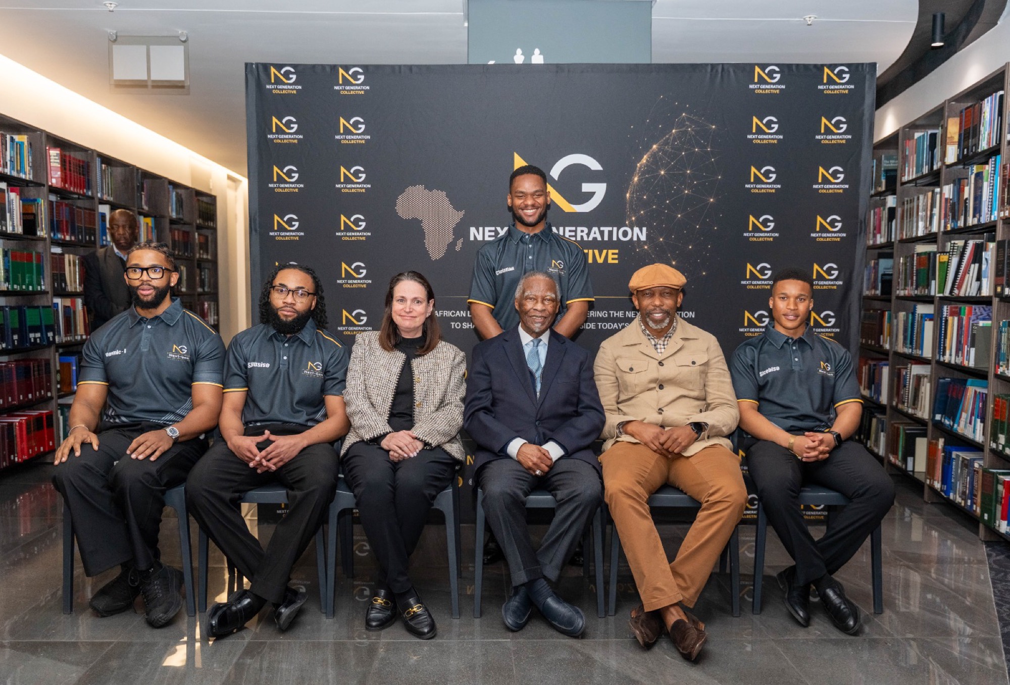 The collective with guests and partners in front of the branded backdrop